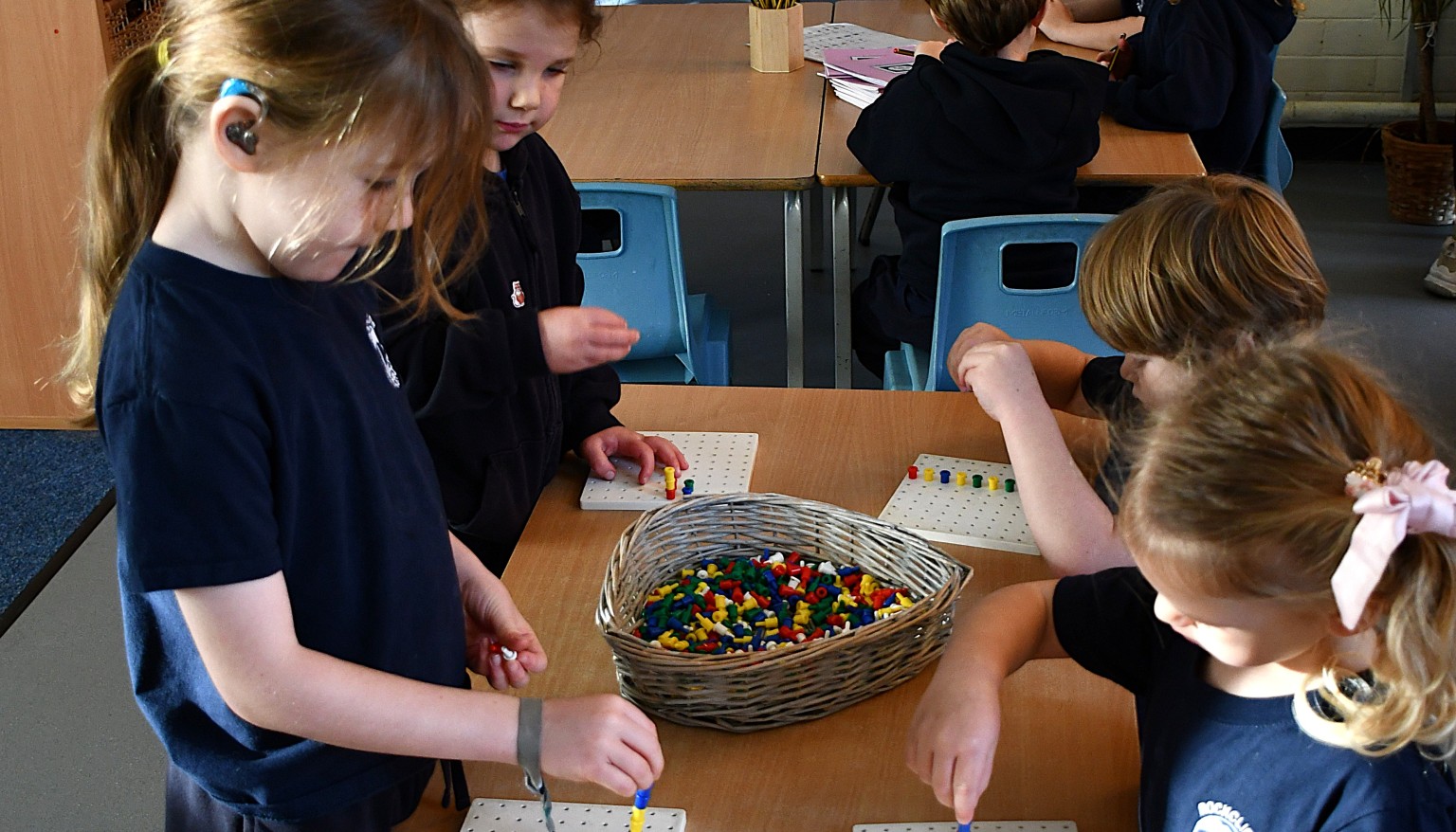 children threading beads