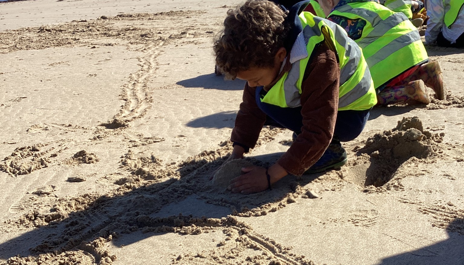 Child drawing in the sand