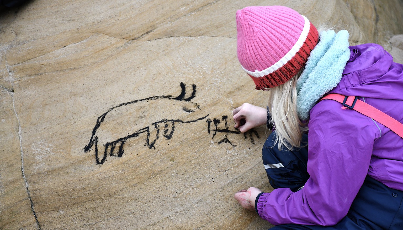 child doing a cave drawing