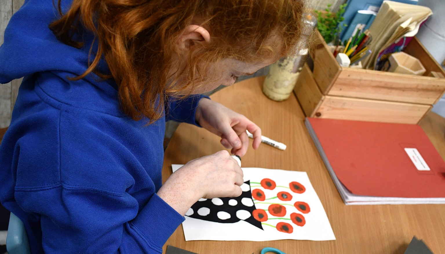 child sticking petals on a picture