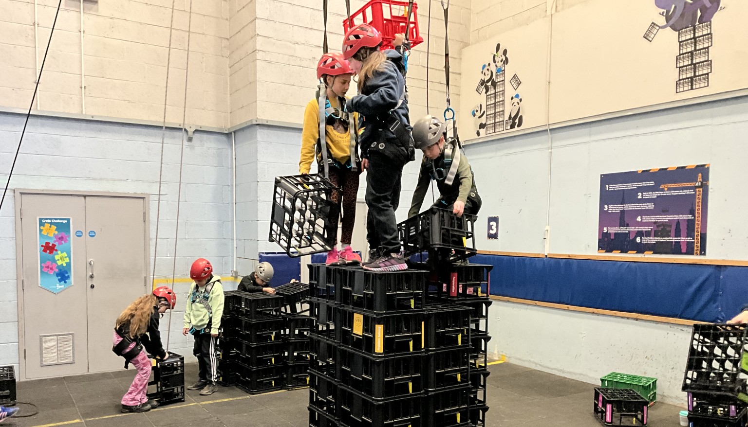 Children building a tower of crates and climbing 