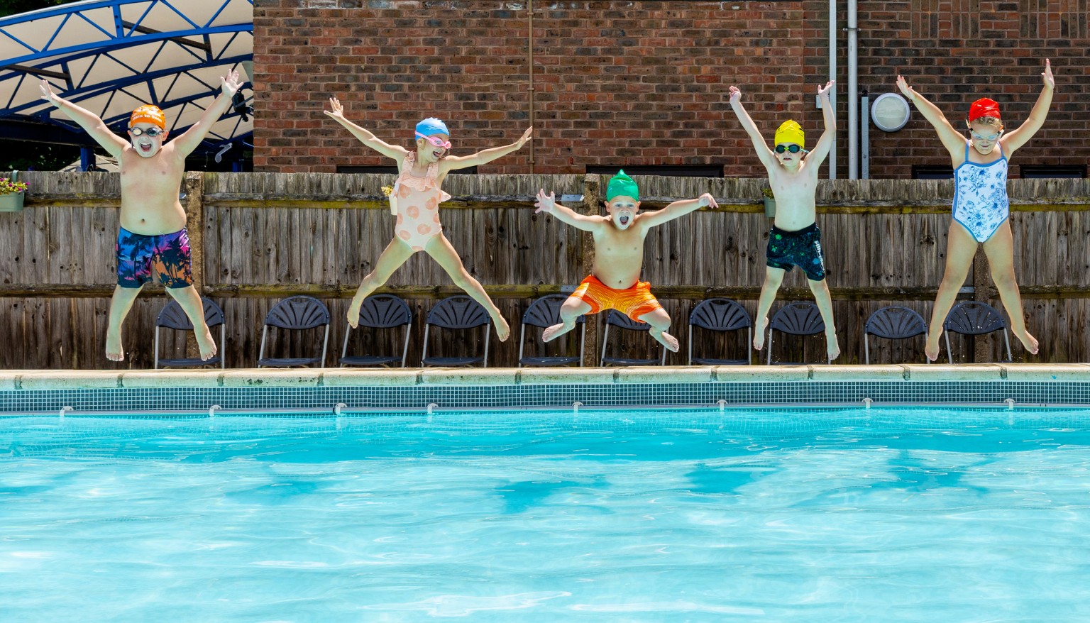Children jumping into a pool 