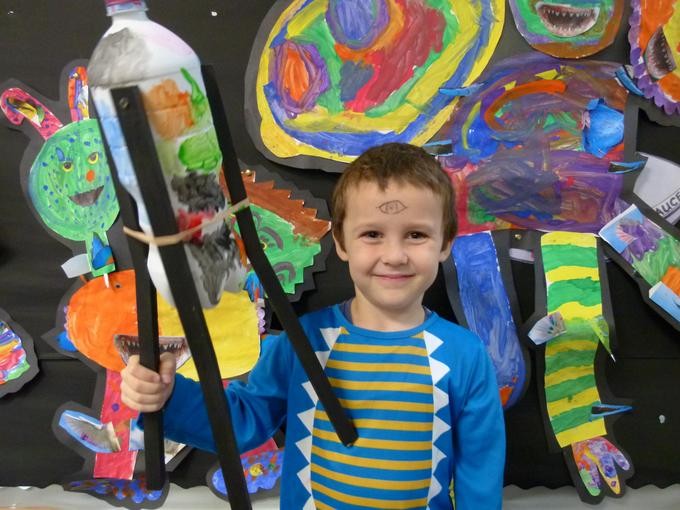 Smiling pupil sharing their colourful artworks