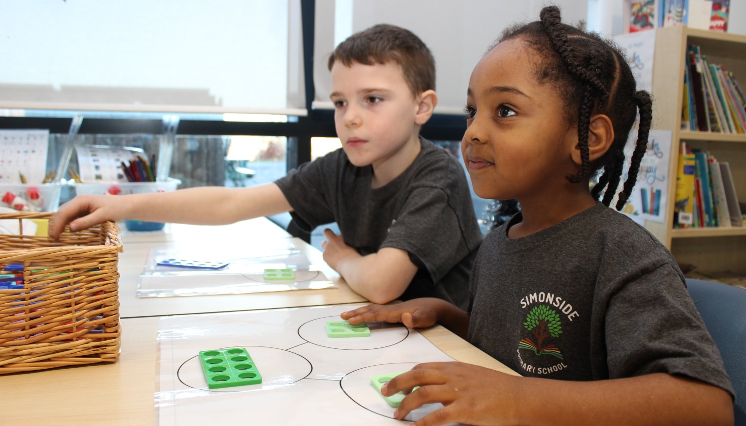 Two children sat at a school desk