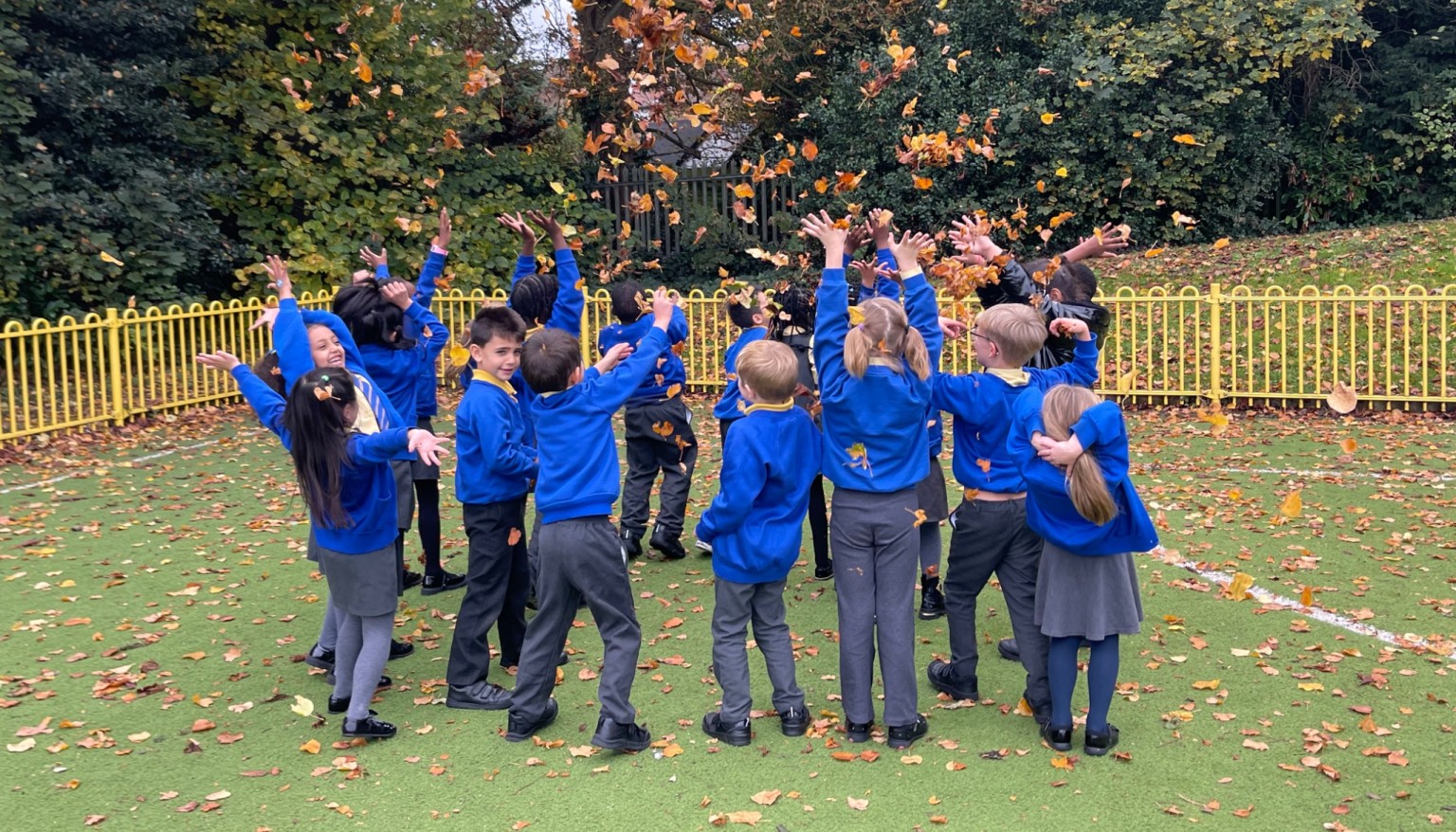 Children throwing leaves in the air 