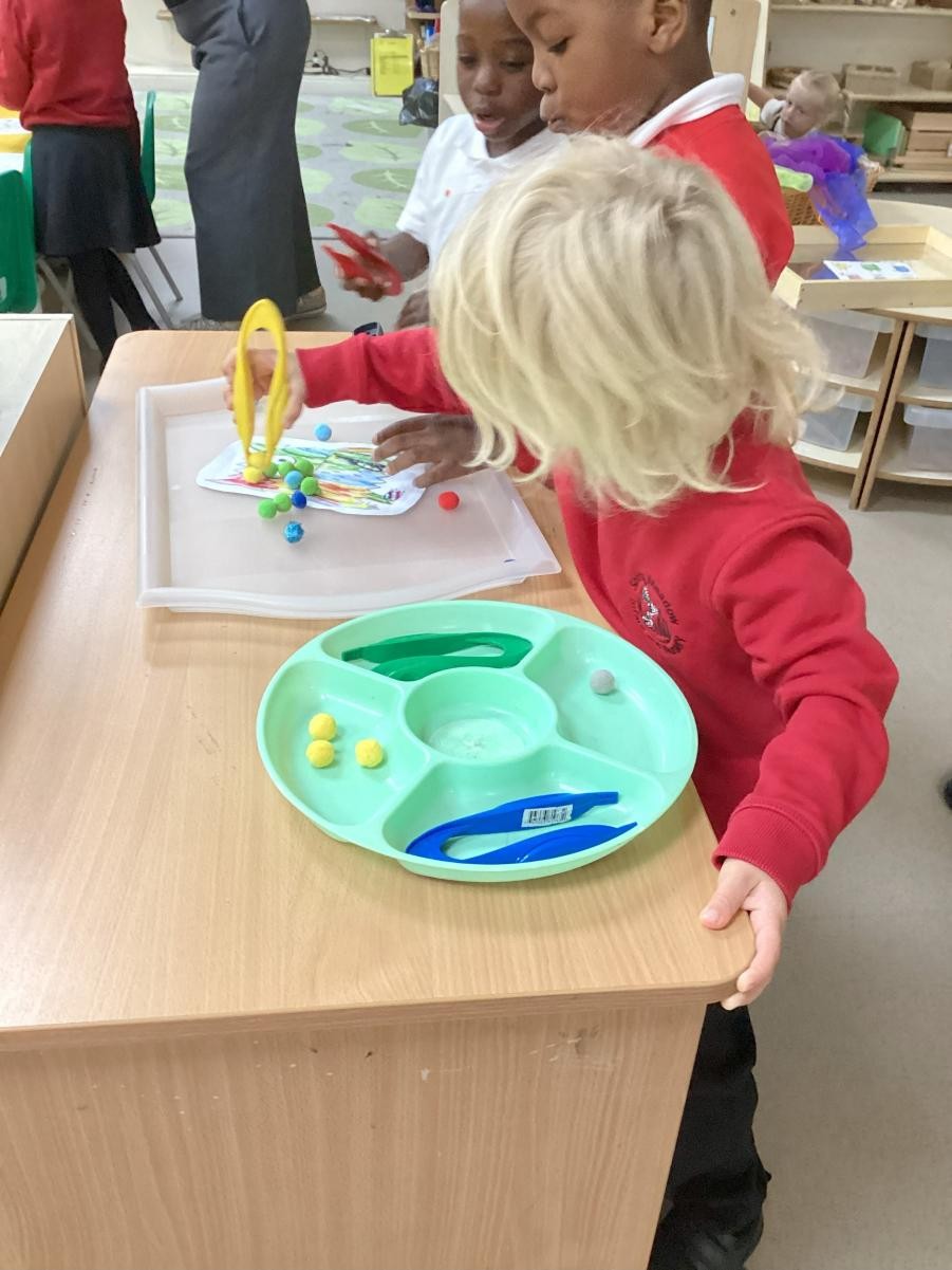 Sorting the Colour Monster's feelings with the help of some tweezers to develop fine motor skills.