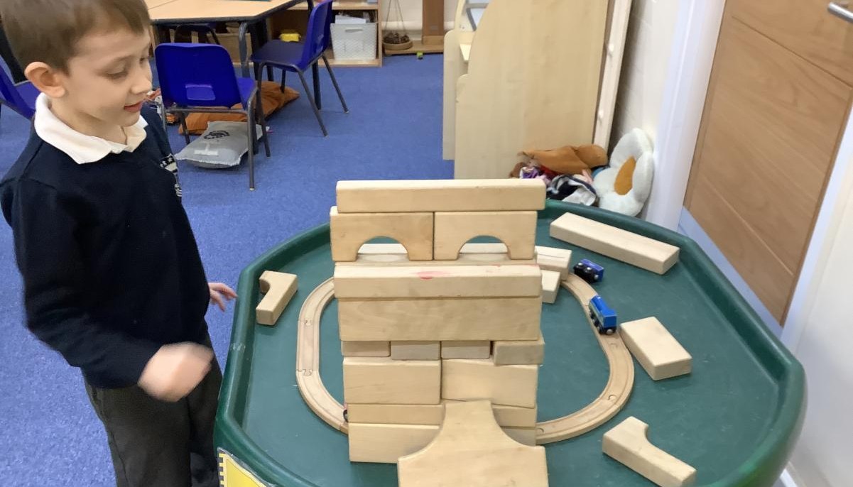The child stood looking at a wooden tower