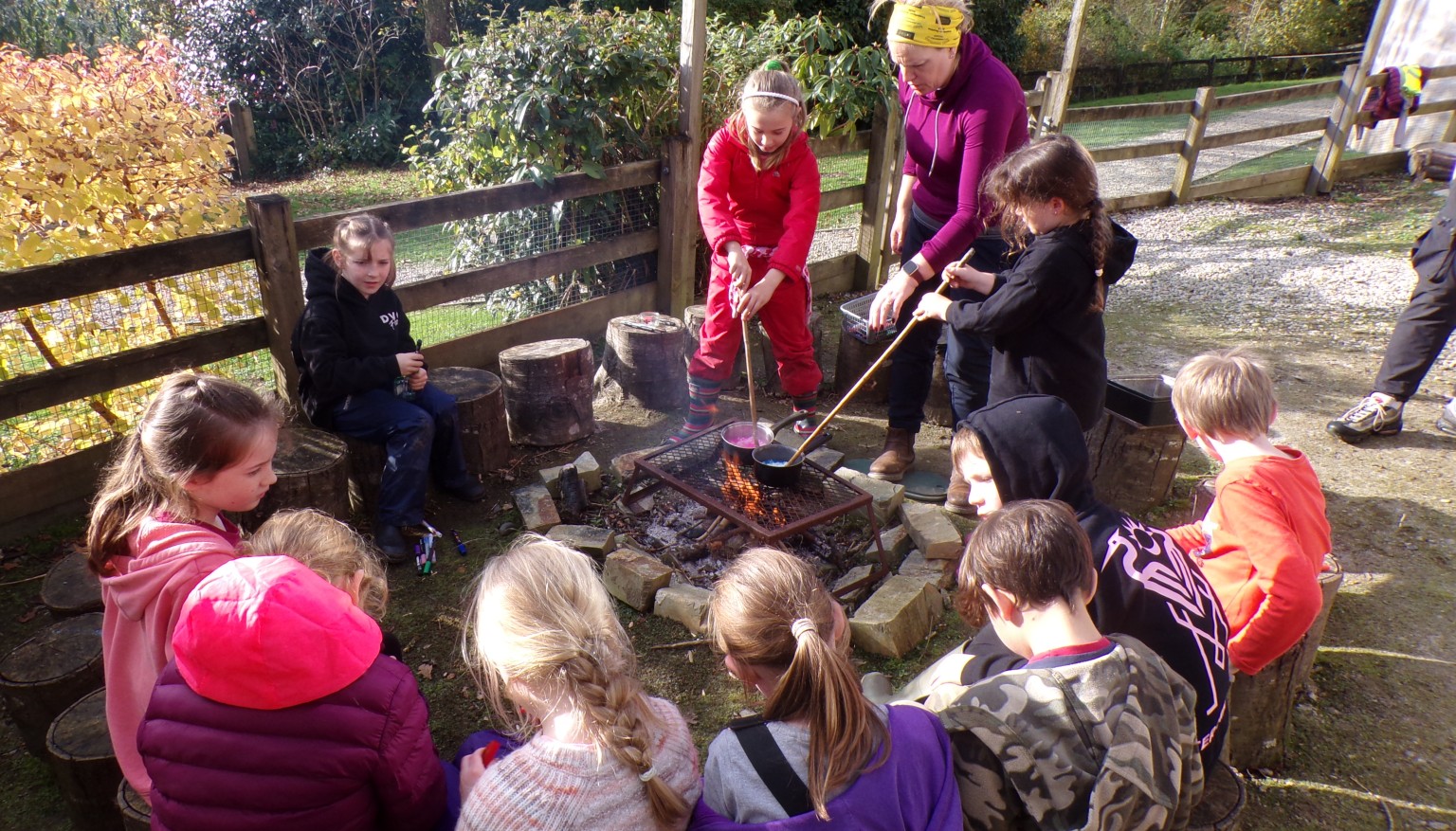 Children sat around forest school fire