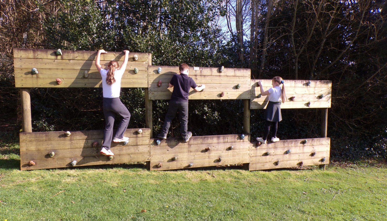 Children on a climbing wall outdoors
