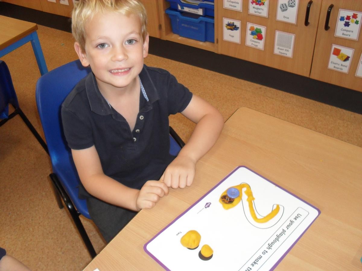 We practised forming numbers and added the correct number of buttons to match.