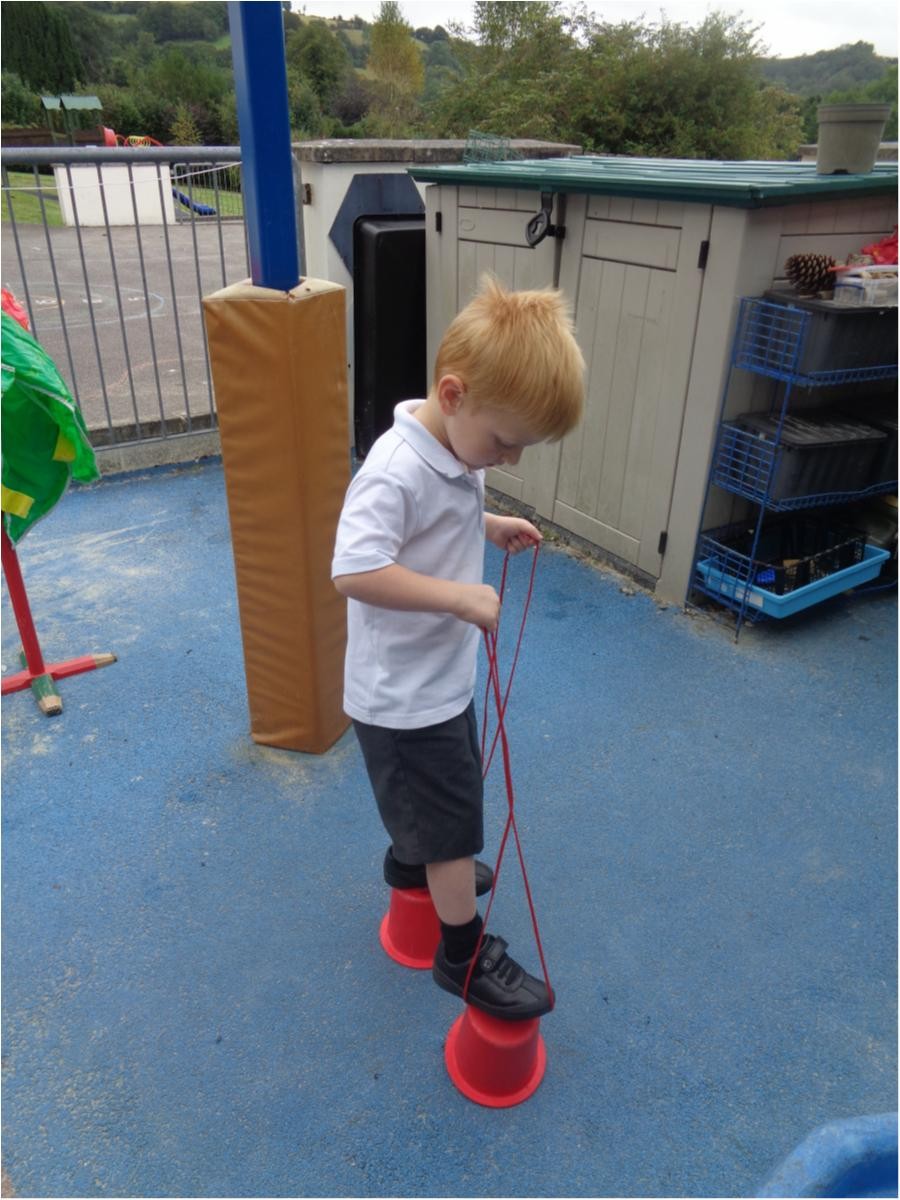 Apollo walks very confidently on the bucket stilts.