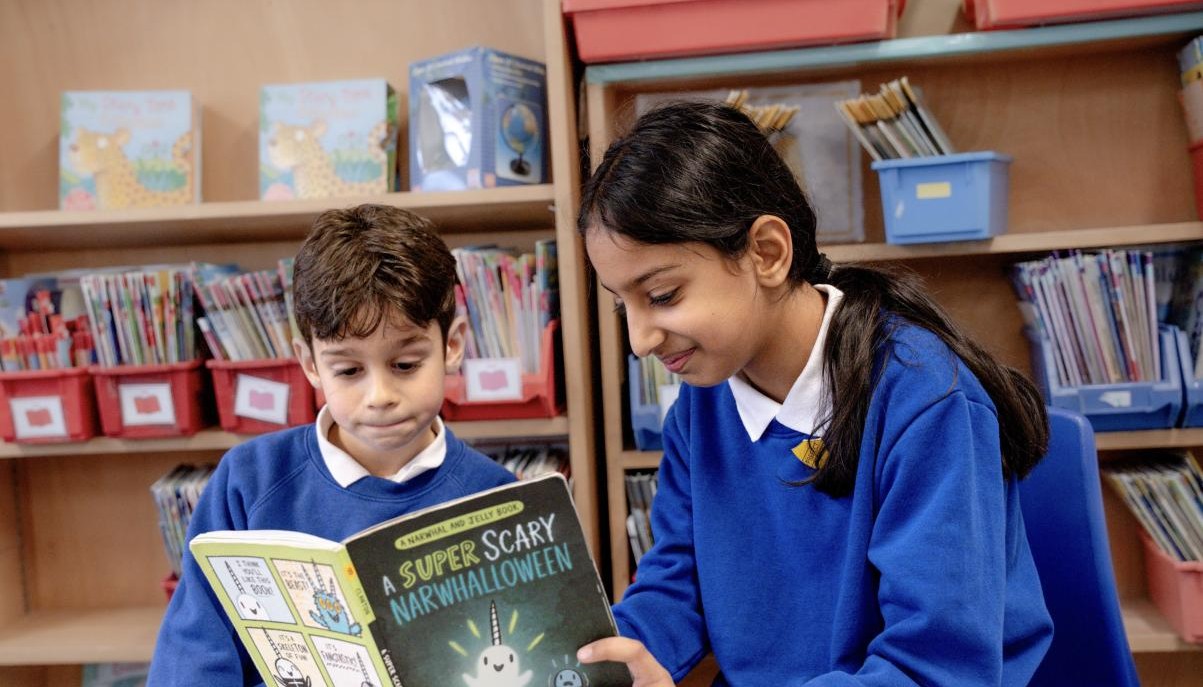 Two children reading a book together