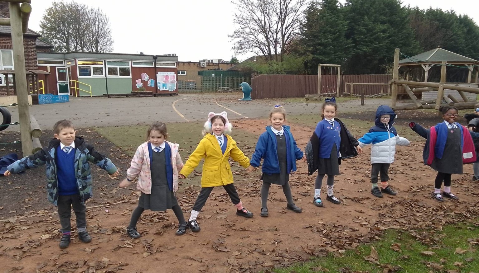 Children stood in a line holding arms out 