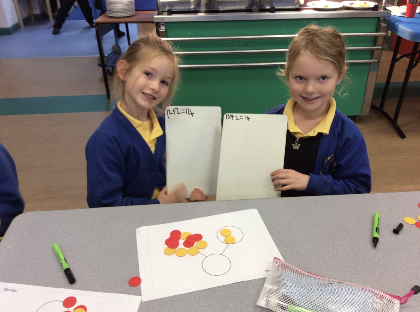 Smiling puupils present their Maths work