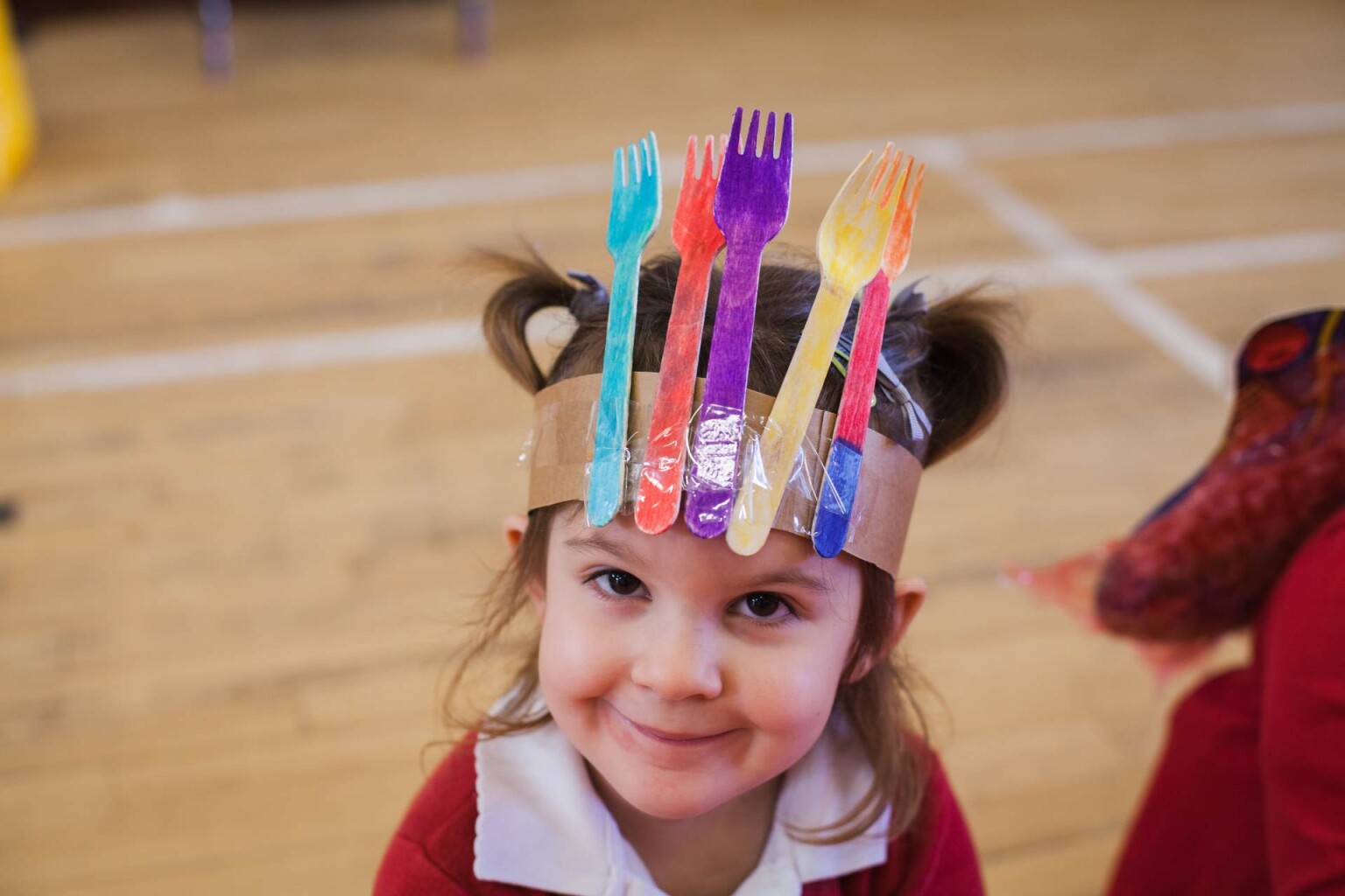 Smiling pupil wearing handmade headdress