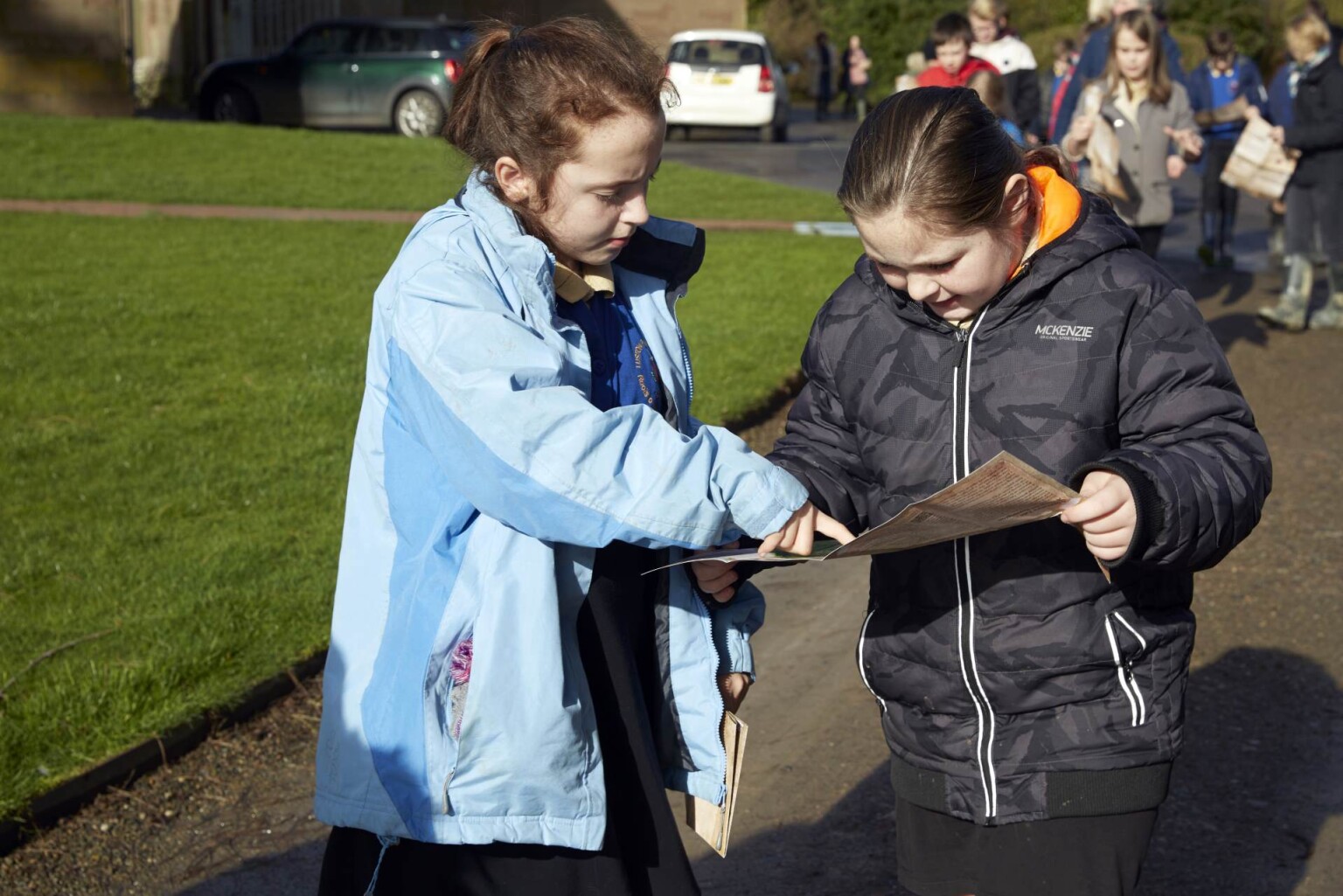 Pupils on the field using a map