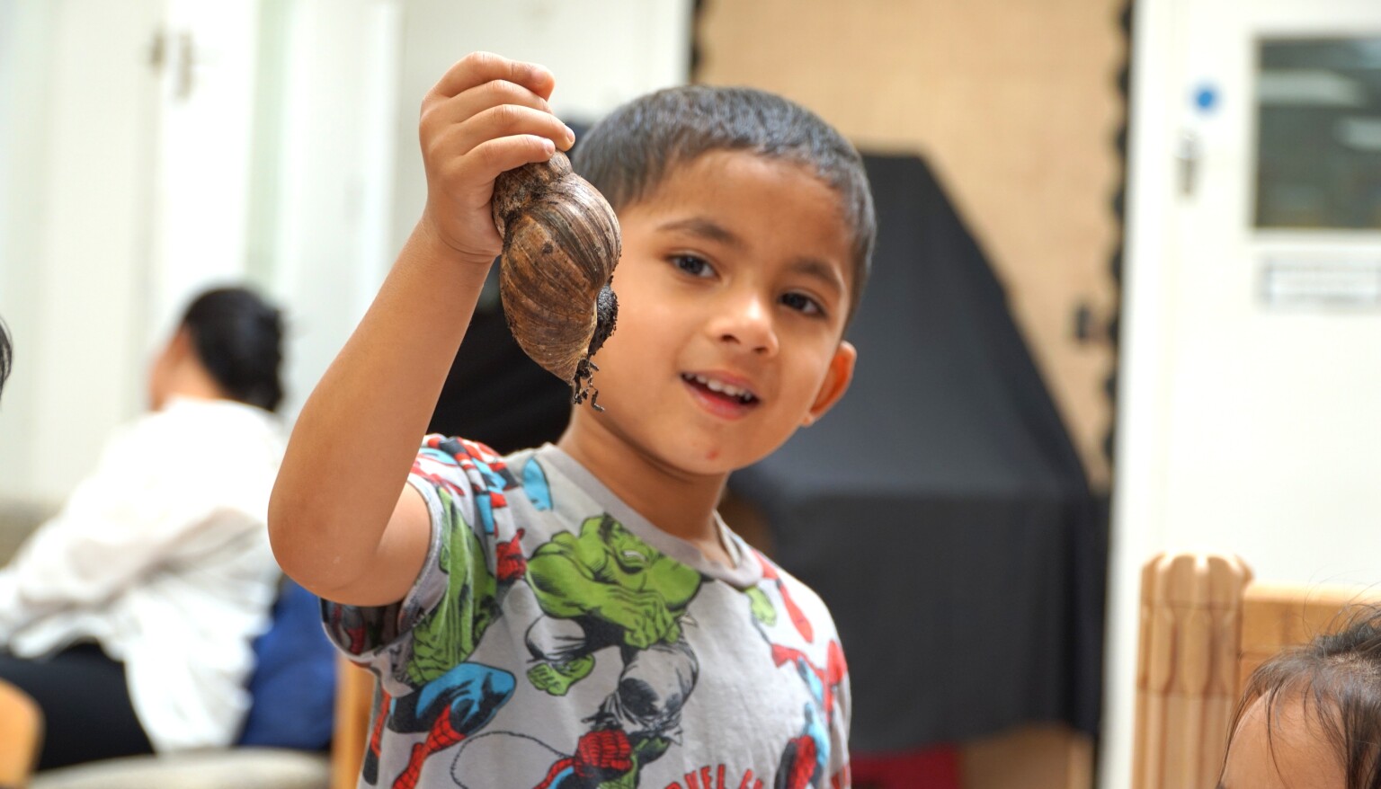 One of the children looks closely at Kendi, our African Land Snail.