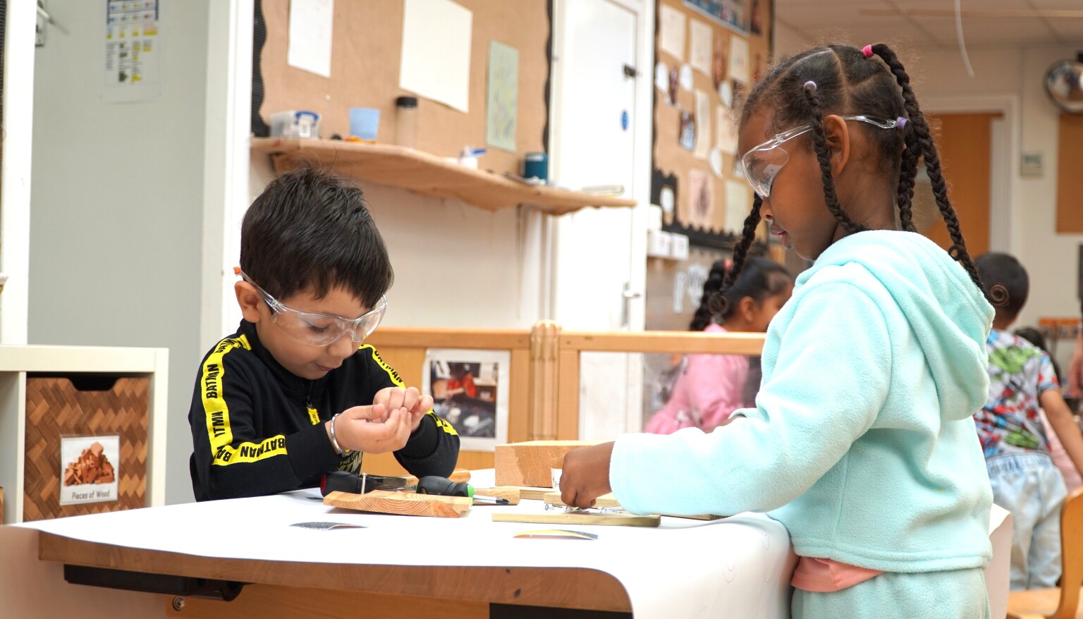 The children enjoy woodwork together.