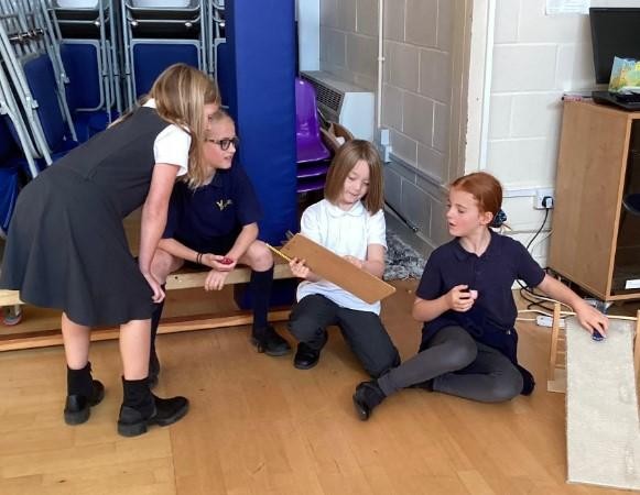 Year 4 children investigating how cars travel on different surfaces