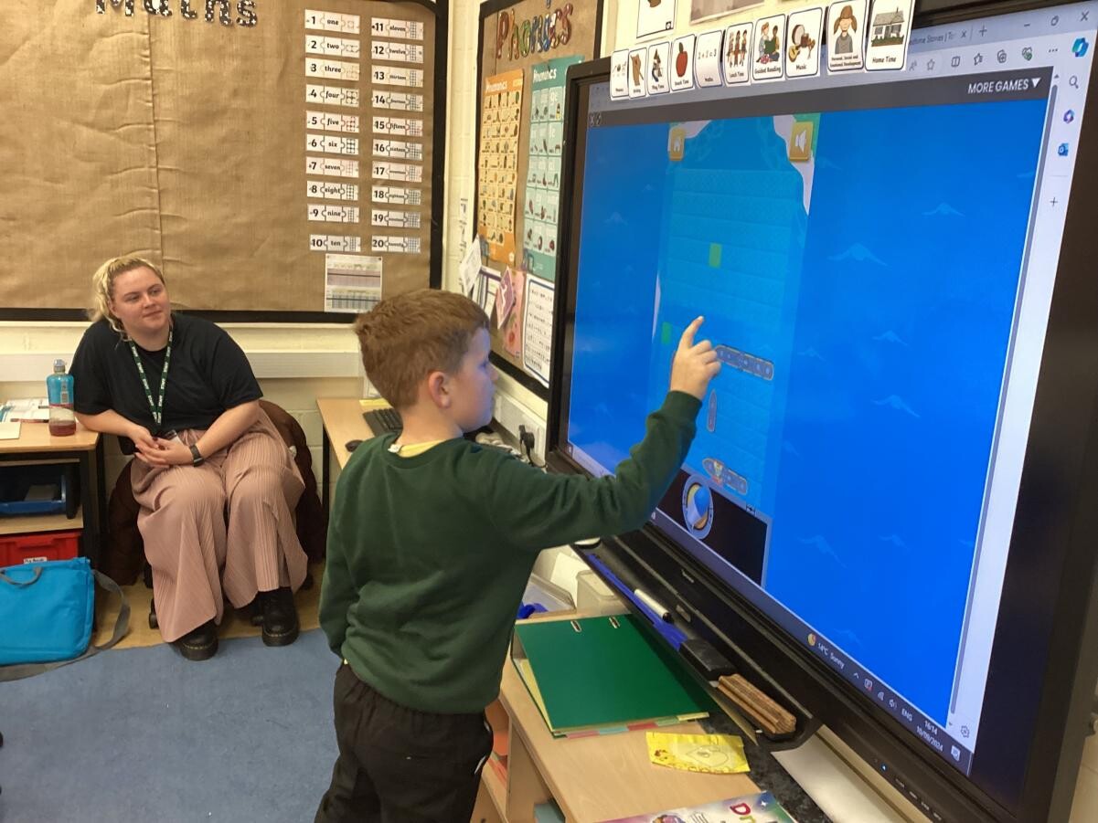 Teacher with child using interactive white board