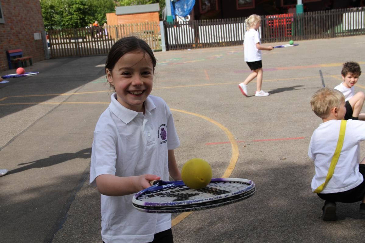 Child holding a ball on a tennis racket