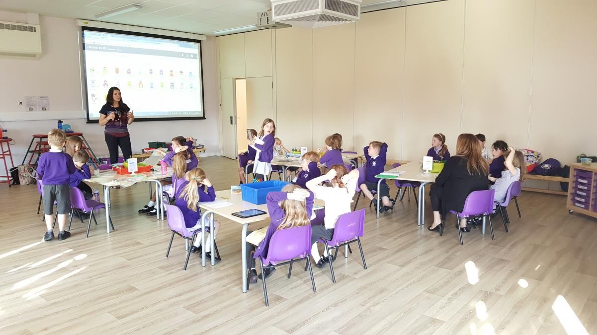 Children sat at tables in hall