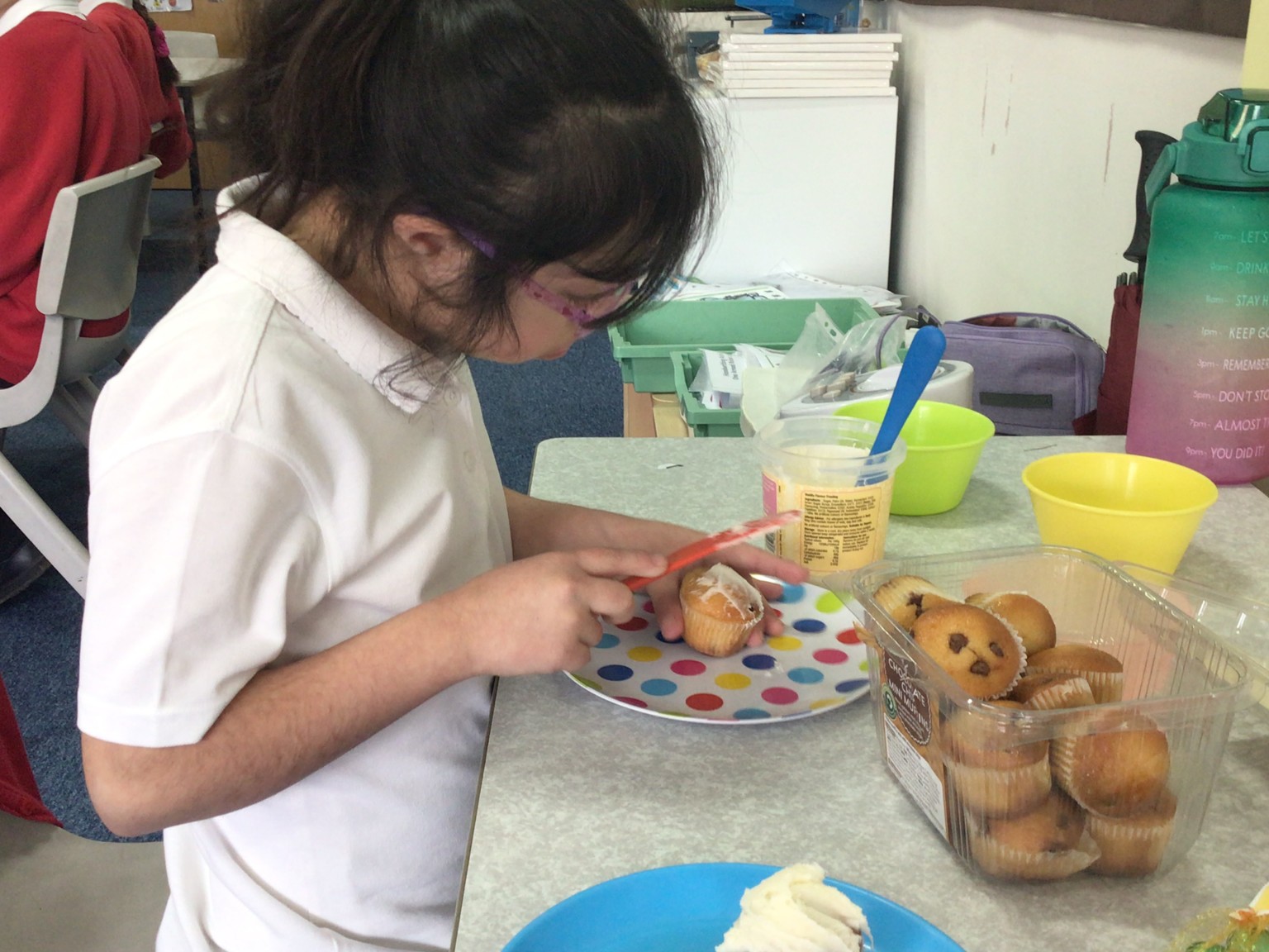 Child decorating a cupcake