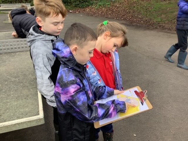 Children looking at a clipboard