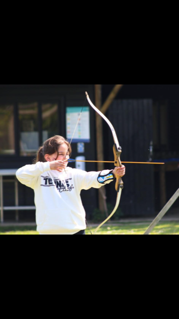 Child aiming a bow and arrow