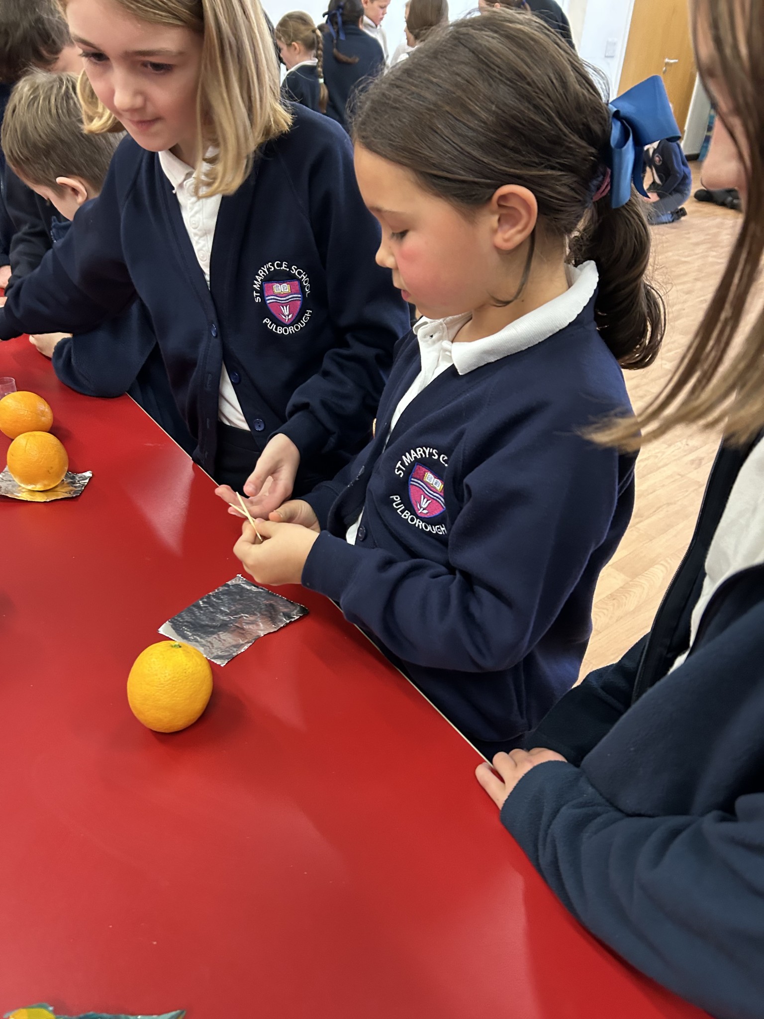 Our children buddy up to make Christingles