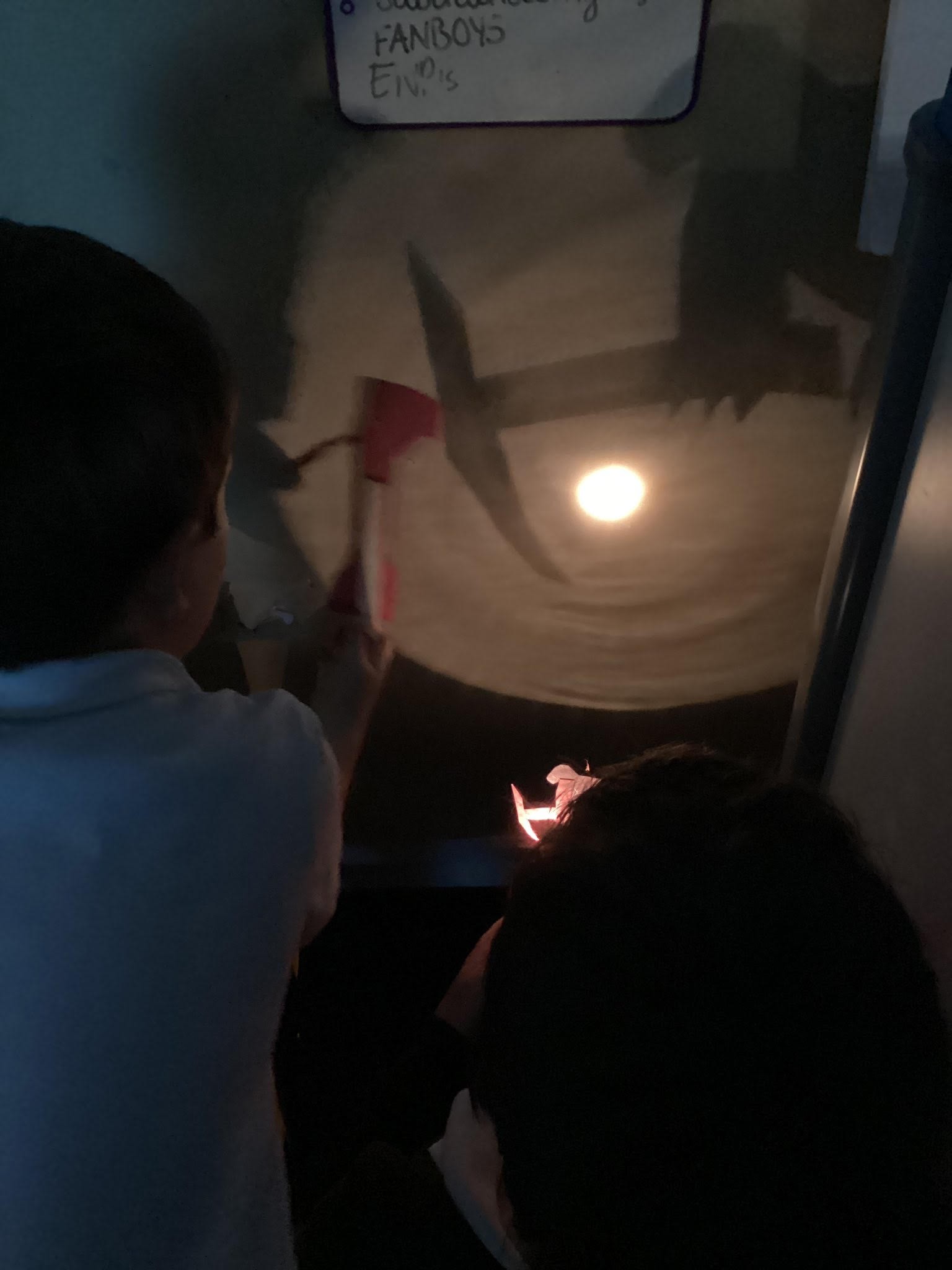 Pupils making their own shadow puppets to discover if they could make them bigger or smaller.
