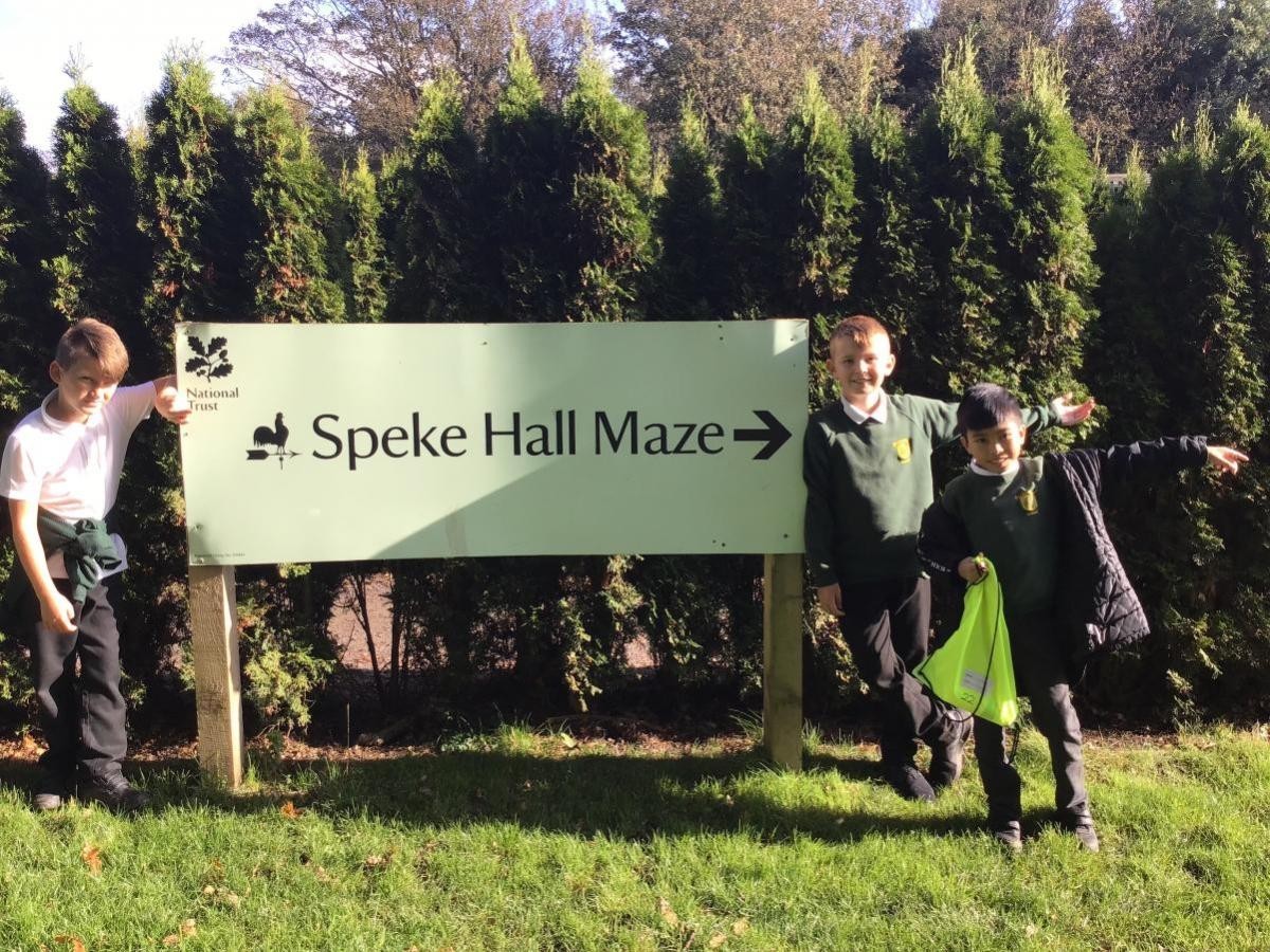 Children stood in front of Speke Hall maze sign