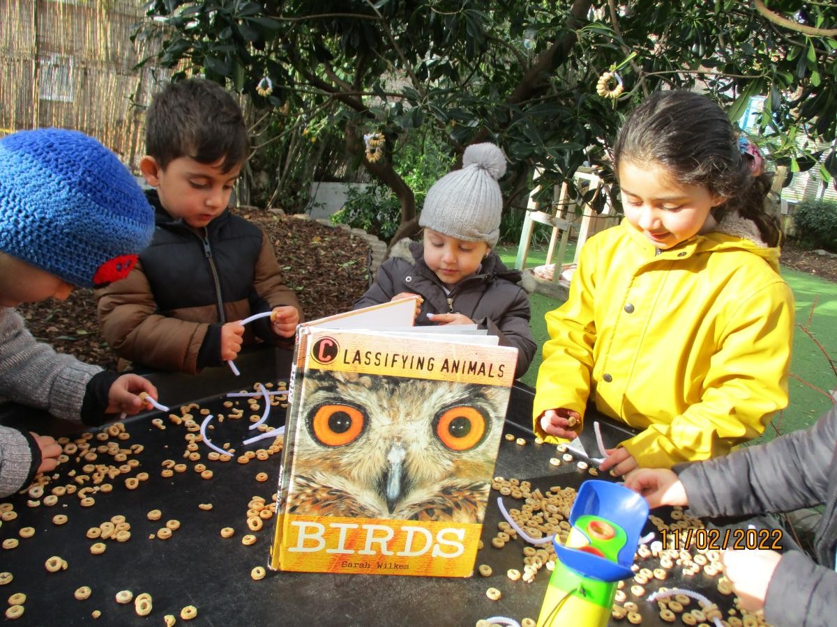 Children looking at a book outdoors