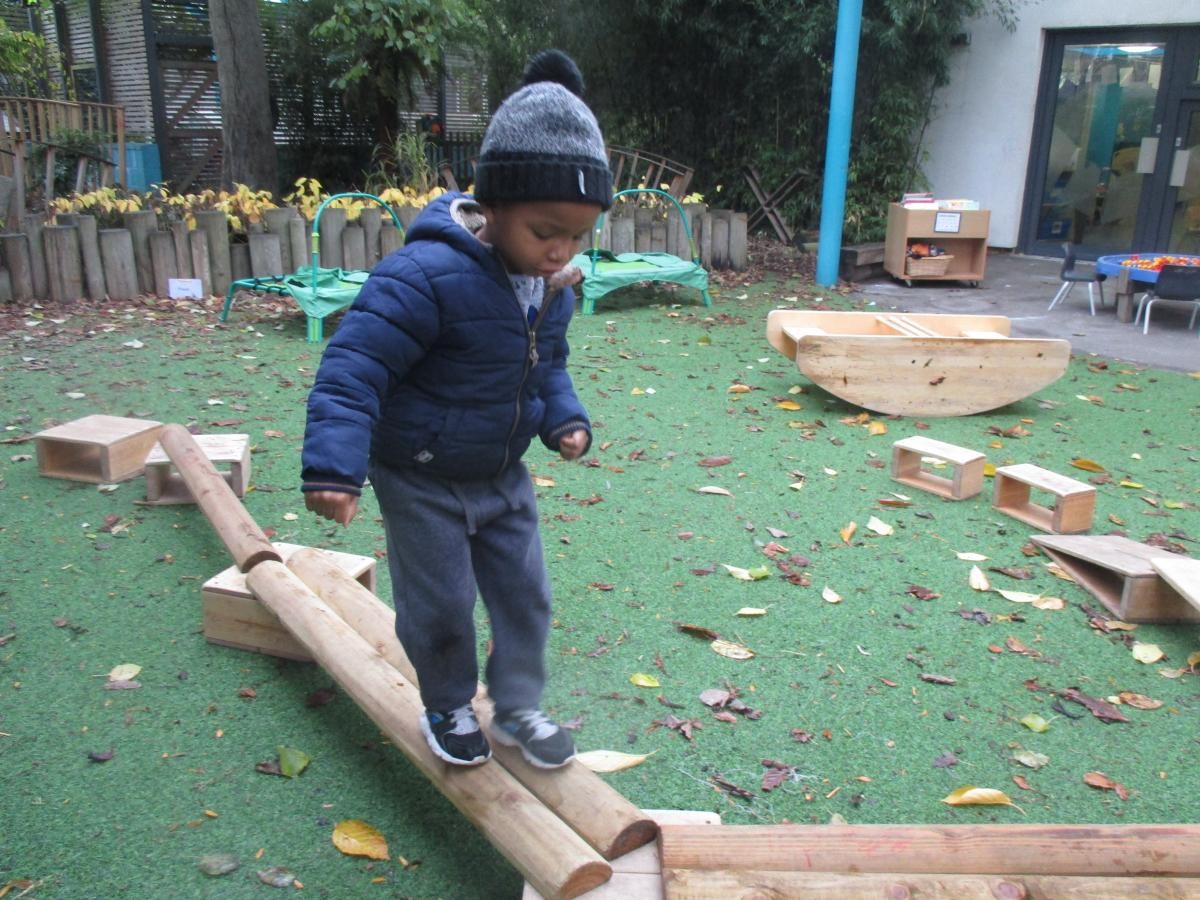 child balancing on a wooden beam 