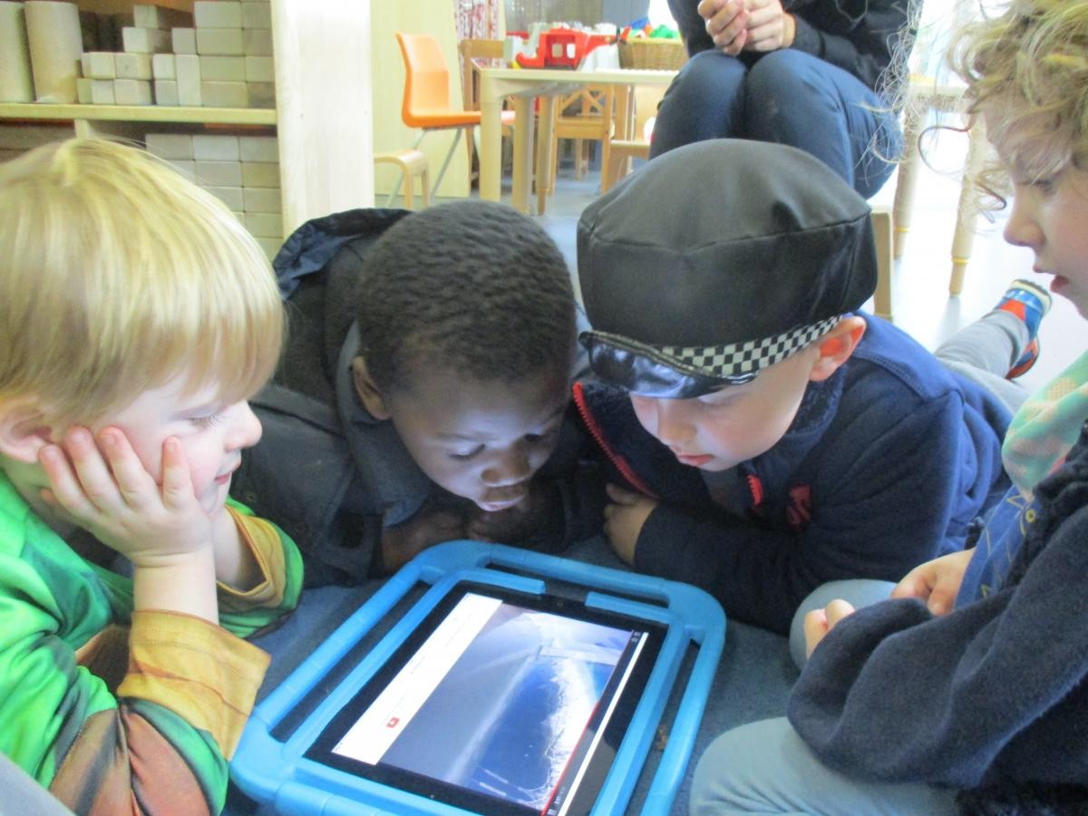 three children looking a a tablet screen 