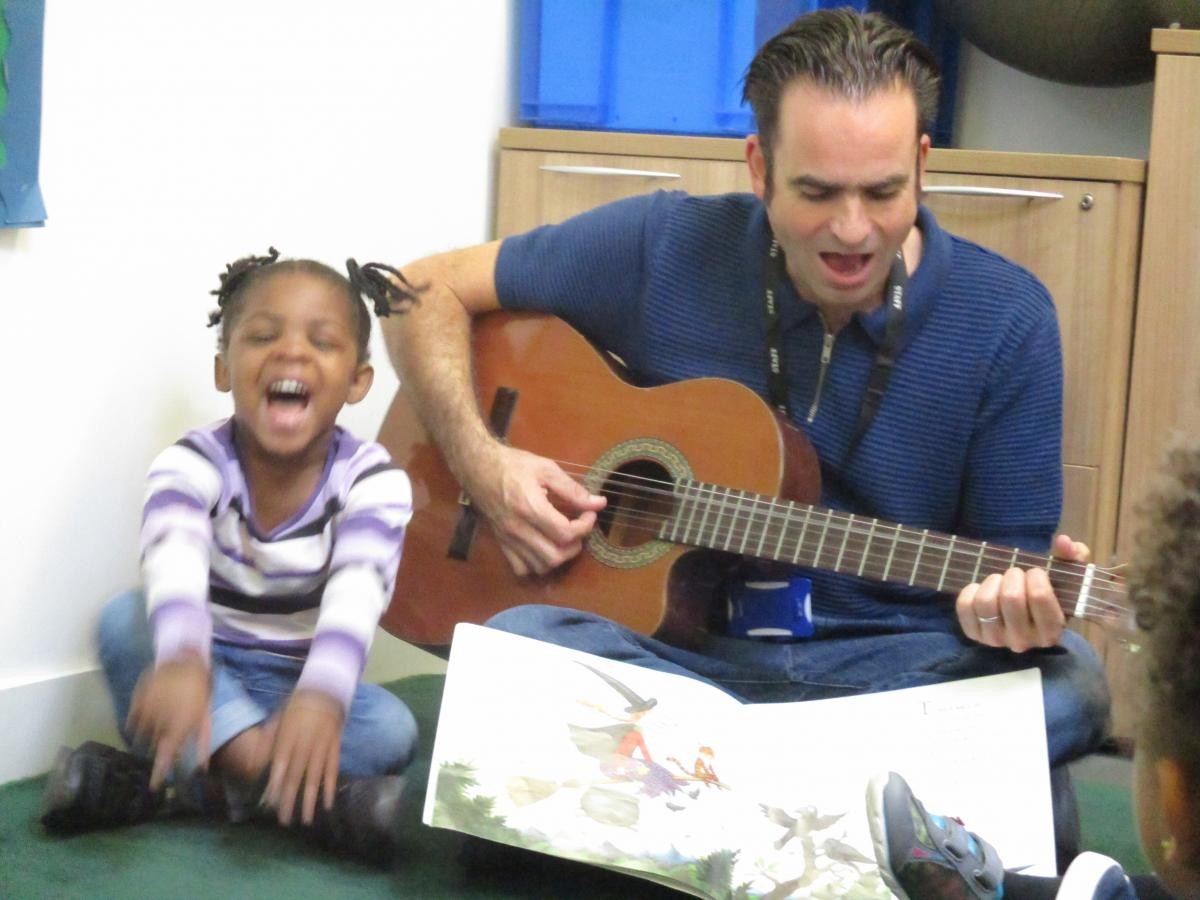 adult playing a guitar 