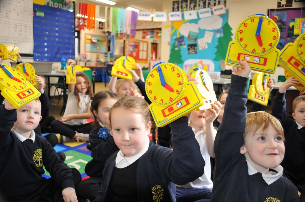 children holding up clocks