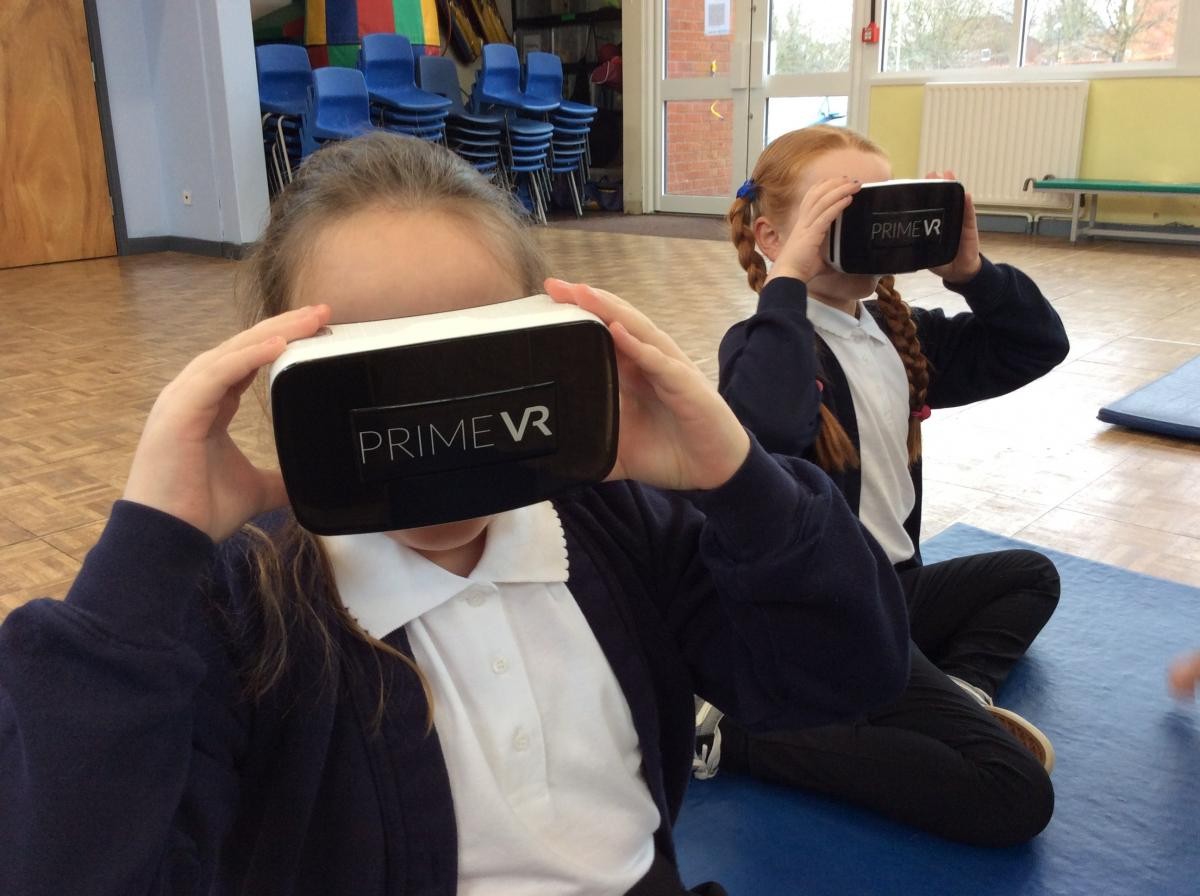 children looking through virtual reality headset