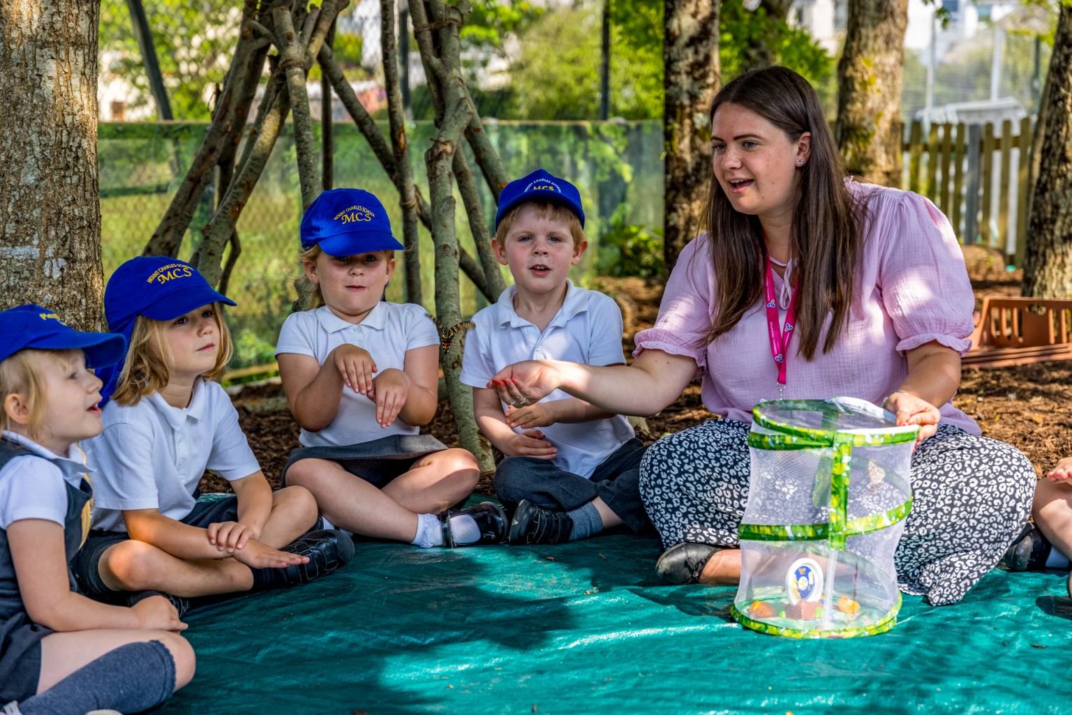 teacher showing pupils a butterfly